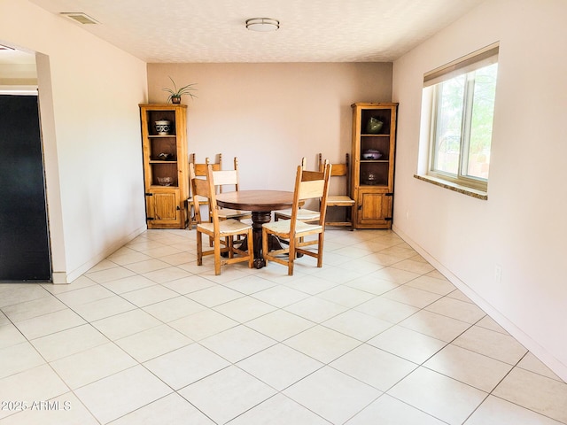 tiled dining area with a textured ceiling