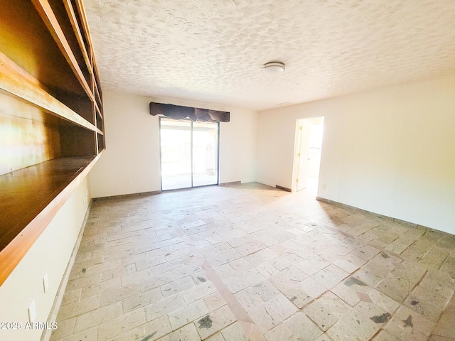 unfurnished room with a textured ceiling