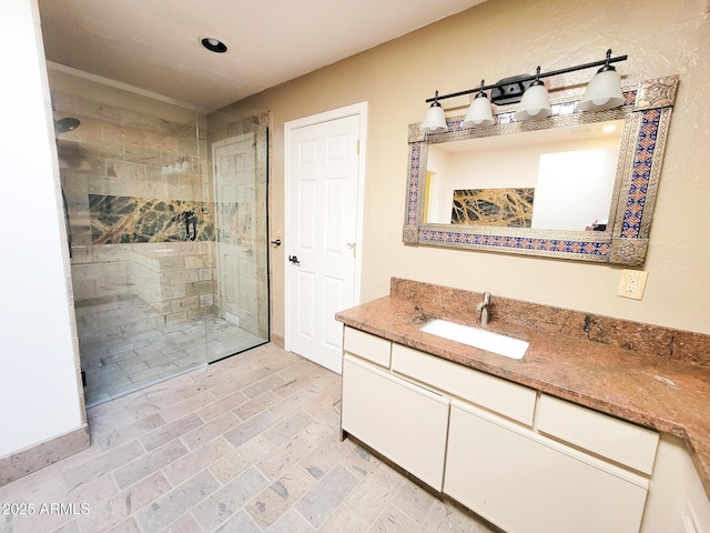 bathroom featuring a tile shower and vanity