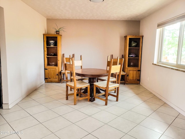 dining area featuring light tile patterned floors and a textured ceiling