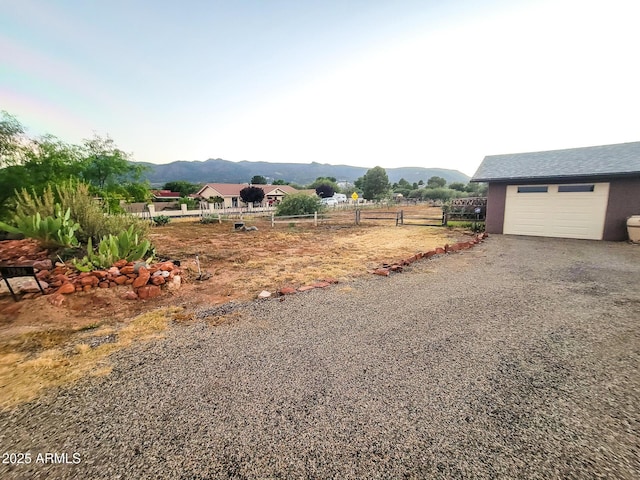 view of yard with a mountain view and a garage