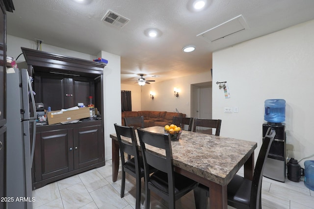 dining space featuring a textured ceiling and ceiling fan