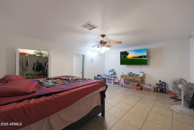 tiled bedroom featuring ceiling fan and a closet