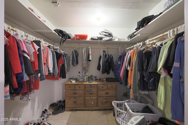 walk in closet with light tile patterned floors