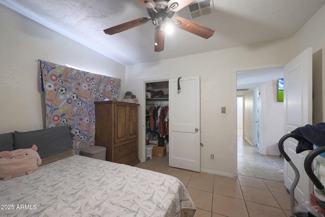 bedroom with a textured ceiling, a closet, ceiling fan, and light tile patterned flooring