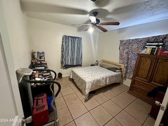 bedroom with light tile patterned floors, a textured ceiling, and ceiling fan