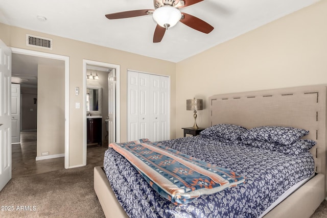 carpeted bedroom with ensuite bathroom, ceiling fan, and a closet