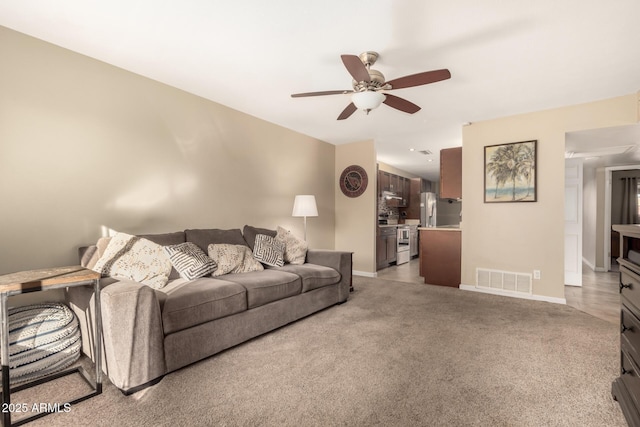 living room featuring ceiling fan and light colored carpet