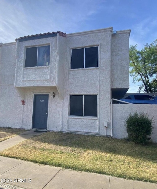 view of property with stucco siding and a front yard
