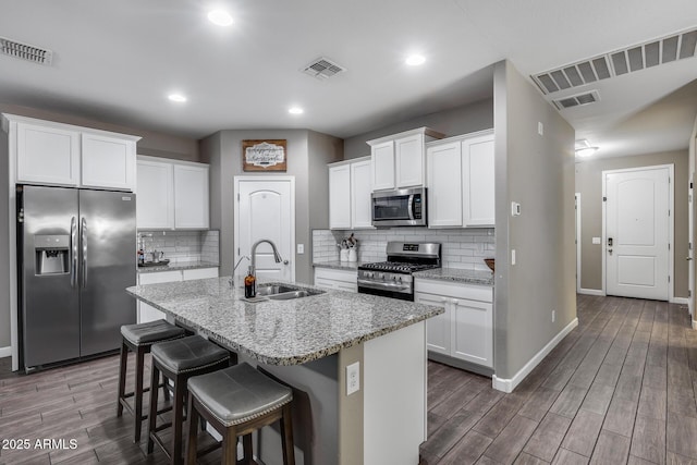 13657 W Paso Trl, Peoria, AZ 85383 - kitchen with appliances with stainless steel finishes, a sink, baseboards, wood finished floors, and tasteful backsplash