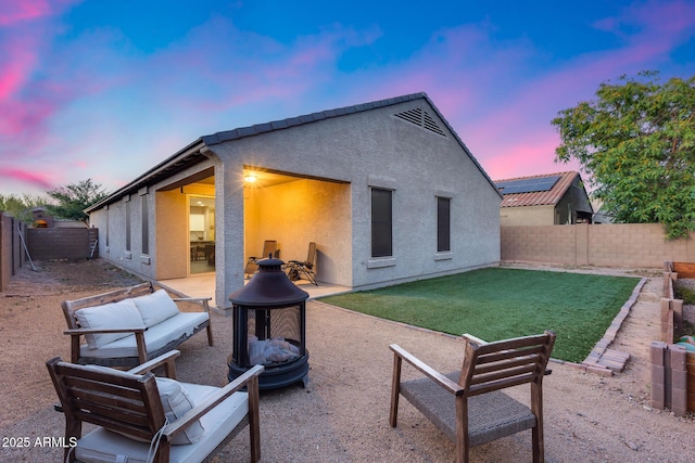 13657 W Paso Trl, Peoria, AZ 85383 - back of house at dusk featuring a fire pit, stucco siding, and a patio area