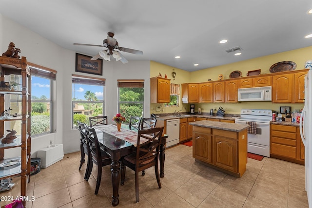 kitchen featuring light tile patterned floors, white appliances, ceiling fan, and a kitchen island