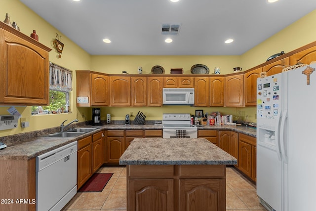 kitchen featuring a kitchen island, sink, light tile patterned floors, and white appliances