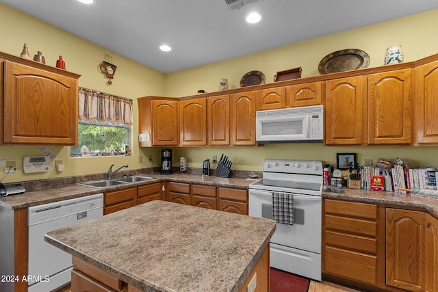 kitchen featuring sink, white appliances, and a center island