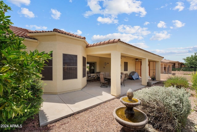 rear view of house with ceiling fan and a patio area