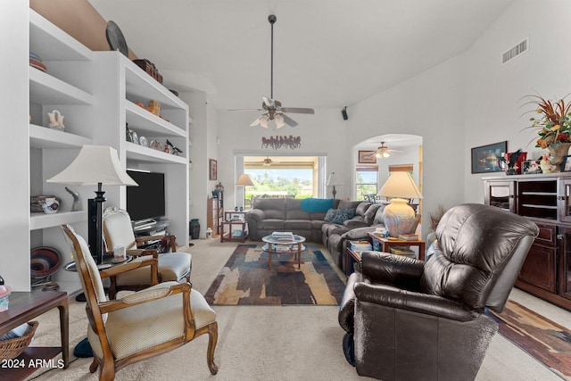 living room featuring a high ceiling, light colored carpet, and ceiling fan