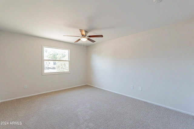 spare room with carpet, ceiling fan, and baseboards