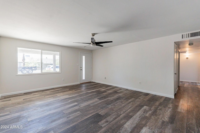 empty room featuring dark wood-style floors, visible vents, ceiling fan, and baseboards