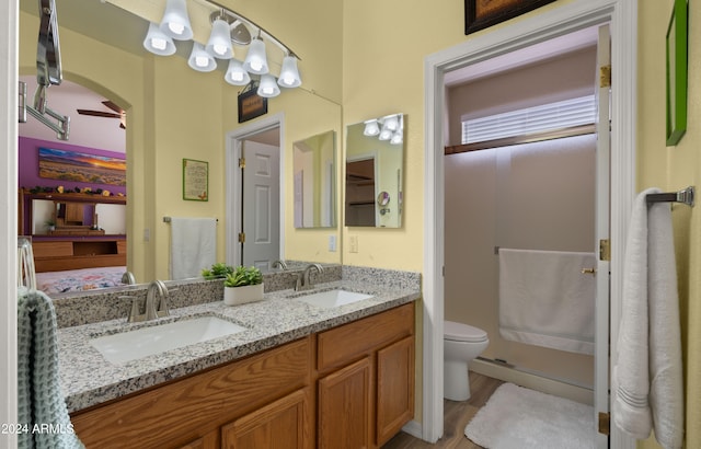 ensuite bathroom with double vanity, wood finished floors, a sink, and ensuite bathroom