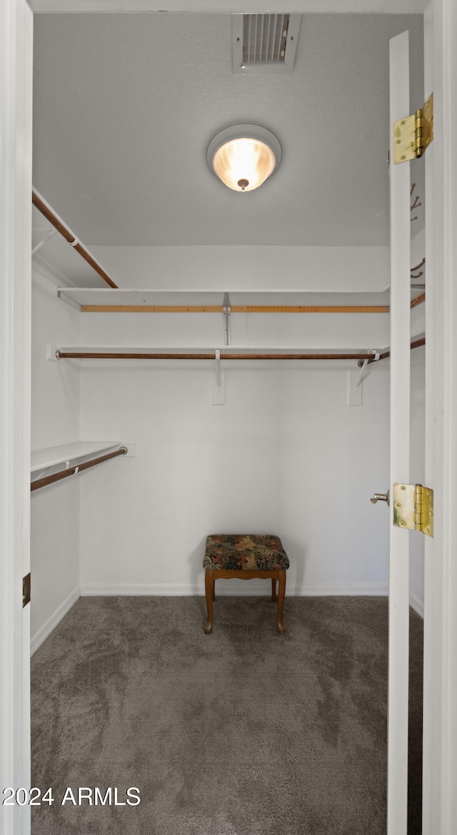 walk in closet with visible vents and dark colored carpet