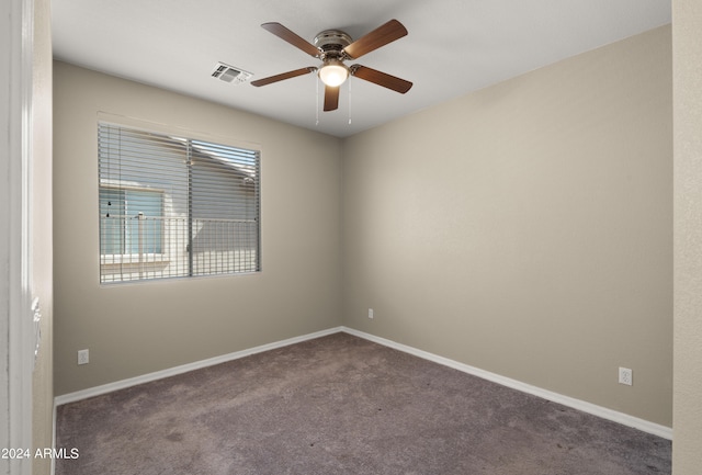 unfurnished room featuring ceiling fan, dark carpet, visible vents, and baseboards