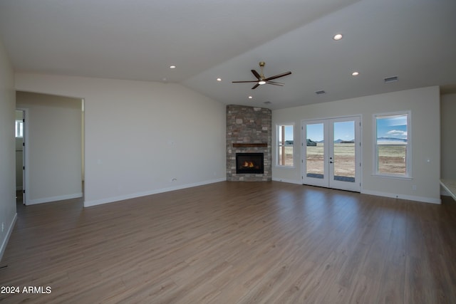 unfurnished living room with french doors, lofted ceiling, a fireplace, and hardwood / wood-style flooring