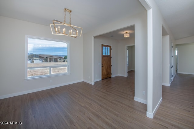 unfurnished dining area with dark hardwood / wood-style flooring and a notable chandelier