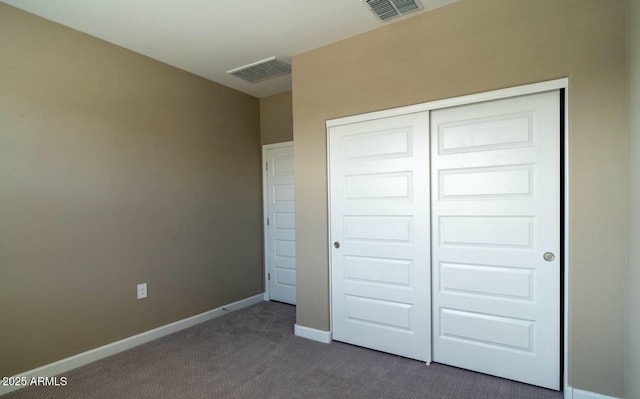 unfurnished bedroom with a closet, baseboards, visible vents, and carpet flooring