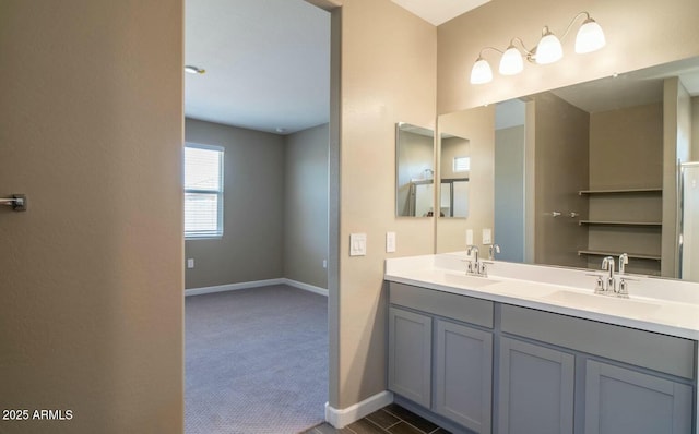 bathroom with double vanity, a sink, and baseboards