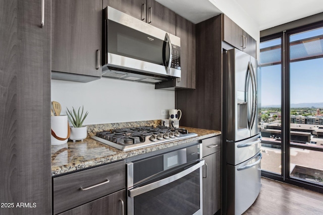 4808 N 24th St Unit 1228, Phoenix, AZ 85016 - kitchen with appliances with stainless steel finishes, dark brown cabinets, wood finished floors, and light stone counters