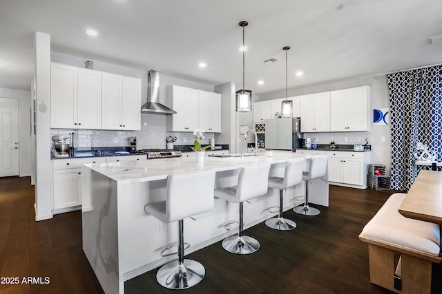 3828 E Liberty Ln, Gilbert, AZ 85296 - kitchen featuring wall chimney exhaust hood, freestanding refrigerator, dark wood-type flooring, a spacious island, and decorative backsplash
