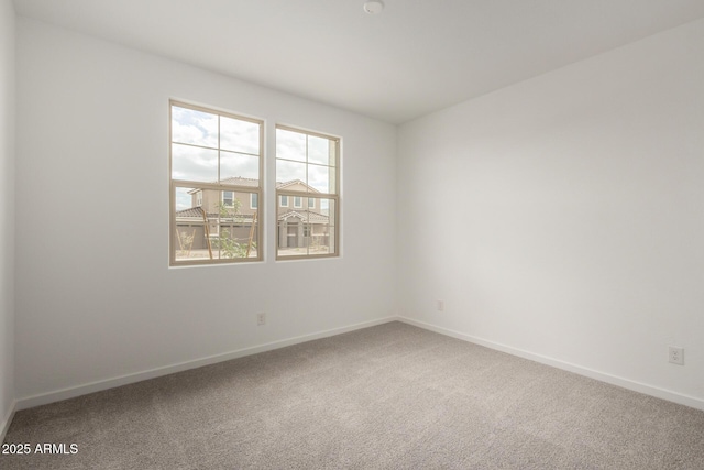 unfurnished room featuring baseboards and carpet
