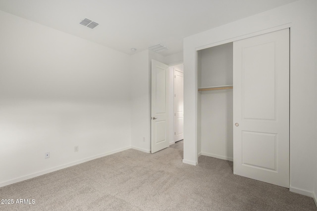 unfurnished bedroom with baseboards, visible vents, carpet, and a closet