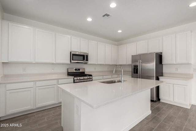 kitchen featuring a sink, wood finish floors, appliances with stainless steel finishes, visible vents, and recessed lighting