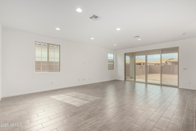 empty room with baseboards, light wood-style floors, visible vents, and recessed lighting