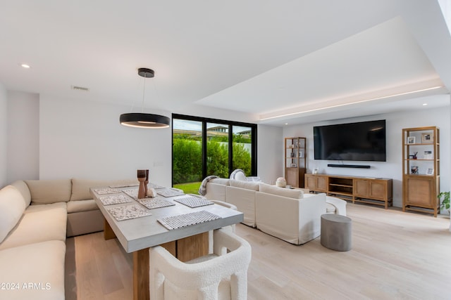 living area with recessed lighting, visible vents, light wood finished floors, and expansive windows