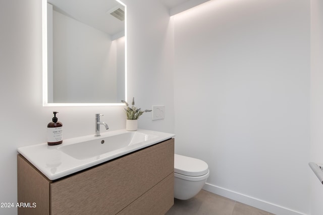 half bathroom featuring visible vents, toilet, vanity, and baseboards