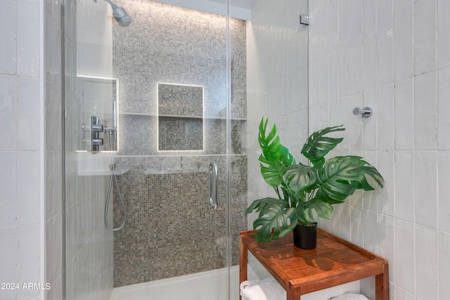 full bathroom featuring a shower stall and tile walls