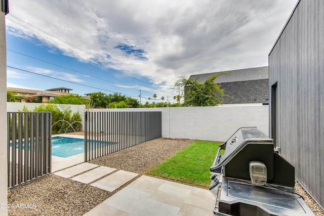 view of patio / terrace with a fenced in pool, a grill, and a fenced backyard