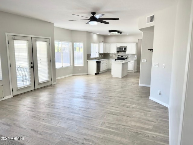 kitchen featuring french doors, sink, white cabinetry, appliances with stainless steel finishes, and light hardwood / wood-style floors