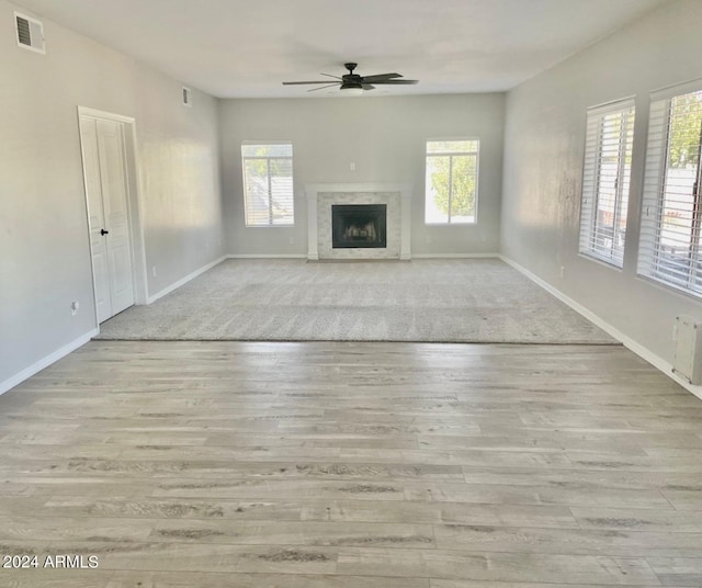 unfurnished living room with light hardwood / wood-style flooring, ceiling fan, and plenty of natural light