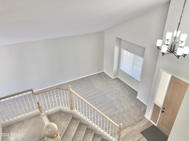 staircase featuring a notable chandelier, a high ceiling, and carpet floors