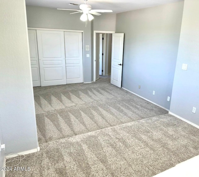 unfurnished bedroom with a closet, carpet, and ceiling fan