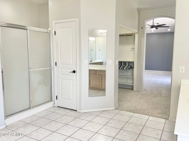 bathroom with walk in shower, tile patterned floors, vanity, and ceiling fan