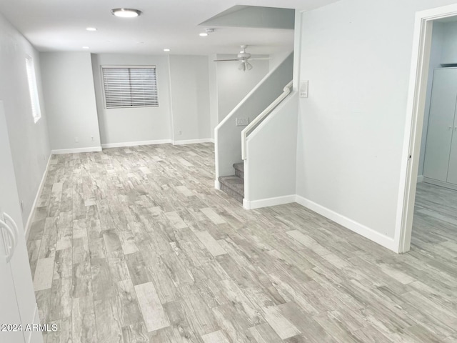 basement with light wood-type flooring and ceiling fan