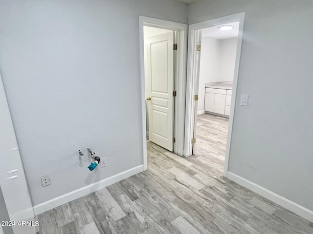 clothes washing area featuring light hardwood / wood-style flooring