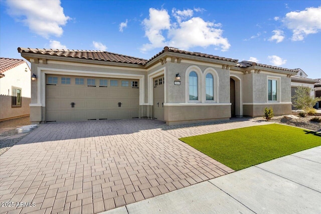 mediterranean / spanish house with a front yard and a garage