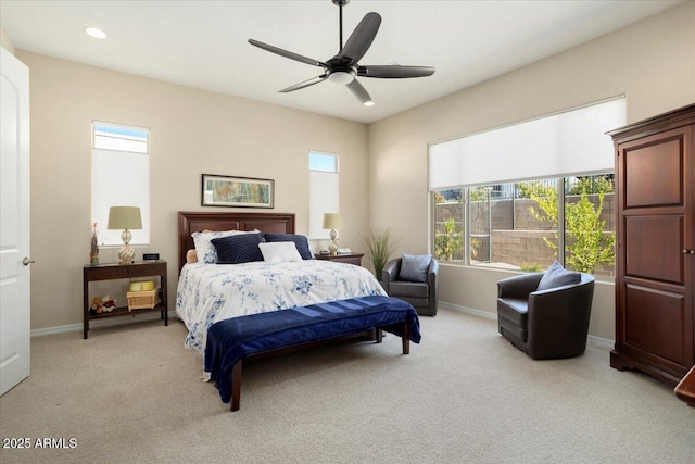 bedroom featuring multiple windows, light colored carpet, and ceiling fan