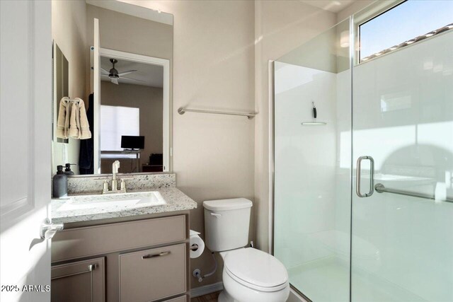 bathroom featuring ceiling fan, toilet, an enclosed shower, and vanity