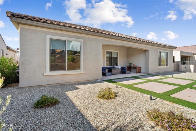 back of house with outdoor lounge area and a patio